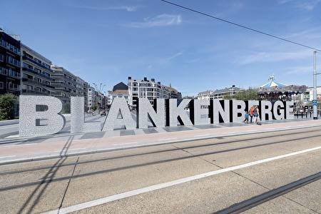 Große Buchstaben buchstabieren das Wort Blankenberge auf einem Platz